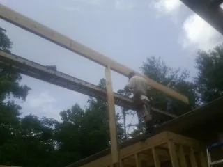 Carpenter setting a ridge beam over a new addition frame — Ice Dam Removal by Roofing Brothers in Wauconda