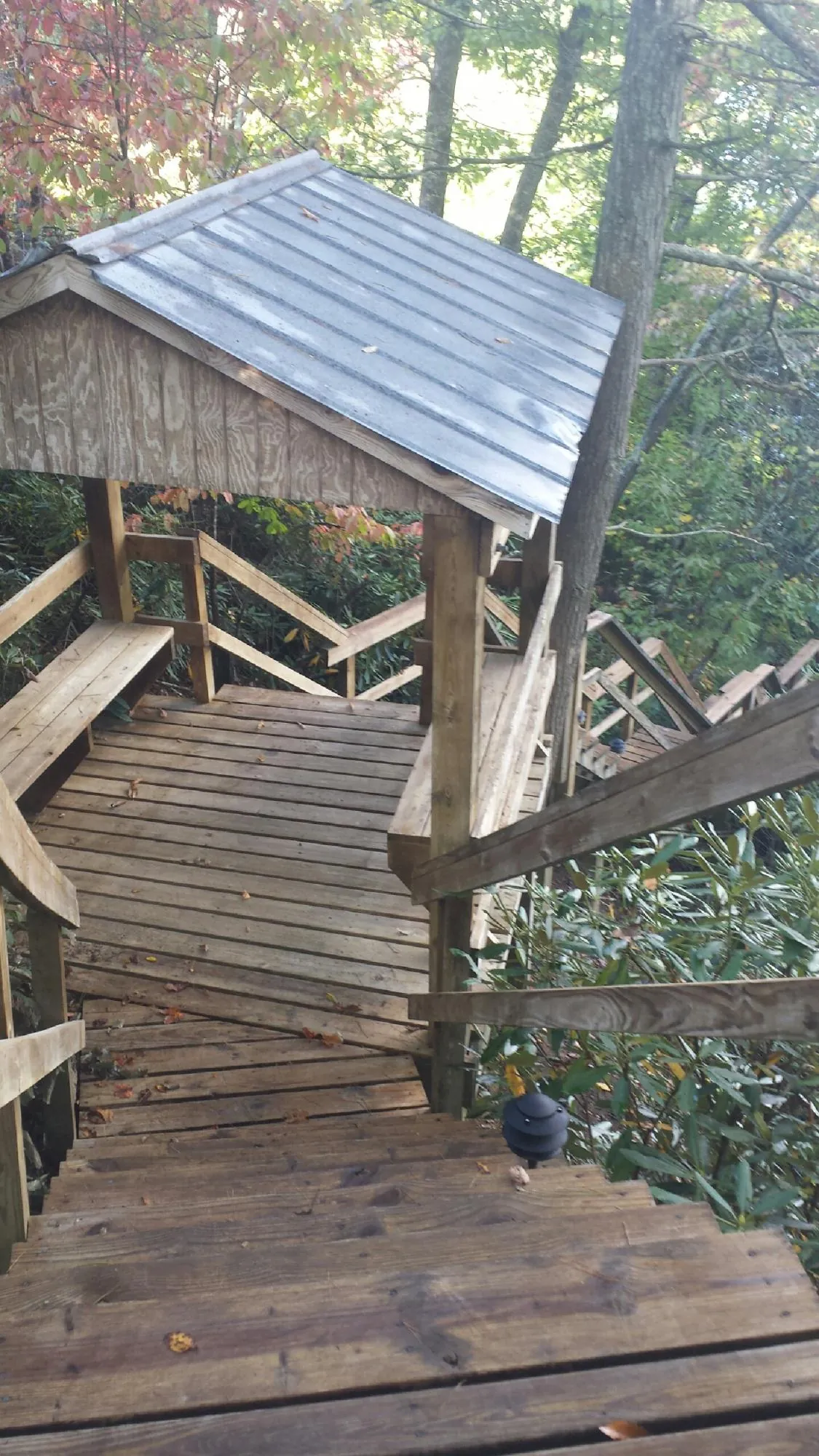 Metal roofed shelter over wooden steps on a wooded walkway — Skylight Repair & Installation work by our crew in Wauconda